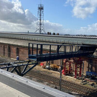 Station footbridge slides through Victorian roof of UK station logo 