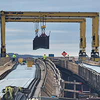 Cranes straddle bridge-gap for widening  logo 